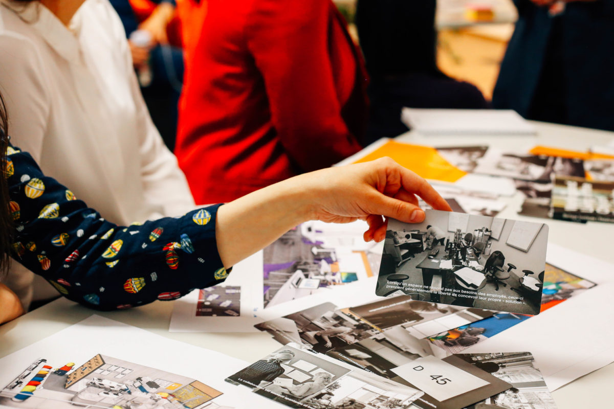 Woman holding a printed photo with other printed photos on table