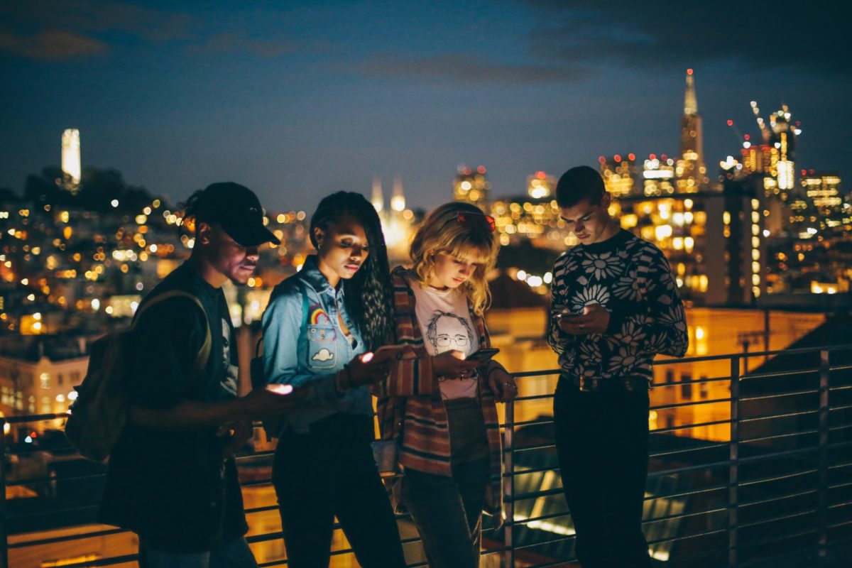 Young people at night looking at mobile phones