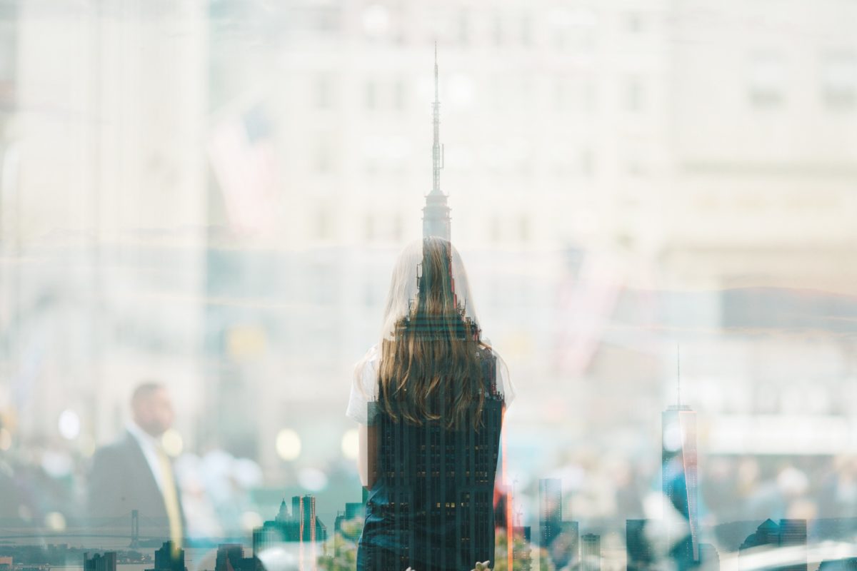 women reflective glass city scene